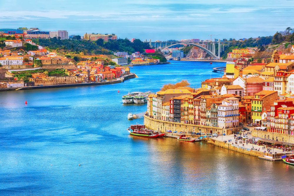 Porto, Portugal old town ribeira aerial promenade view with colorful houses, Douro river and boats